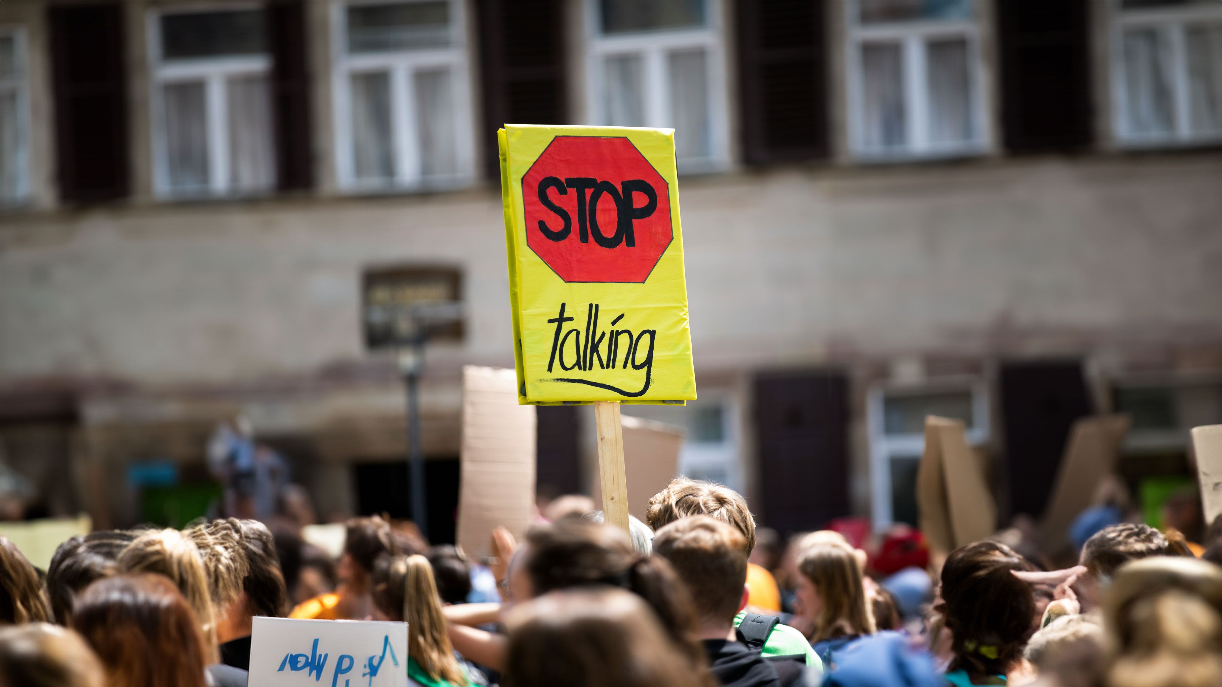 Demonstrationsschild auf dem "Stop talking" steht.